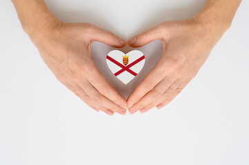 The national flag of Jersey in female hands. The concept of patriotism, respect and solidarity with...