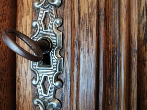 Schlüssel im Schloss an einem alten Holzschrank
