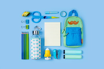 School stationery is arranged neatly on blue background. Pencil case with stationery supplies. Concept back to school. Workplace organization