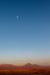 Sunset at the Moon Valley (Valle de la Luna) with the Licancabur volcano and the moon in the background, Atacama, Chile, South America