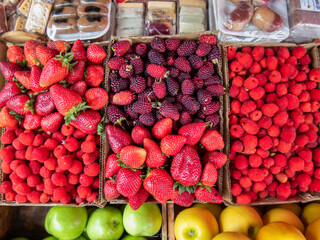 zenithal view of several boxes full of berries, such as strawberries and blackberries