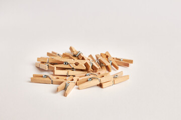 Many miniature wooden clothespins on a white background.