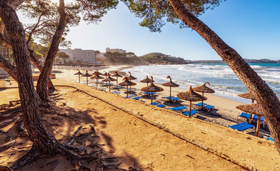 deserted morning sea beach with sunny screens. Platja Gran de Torà