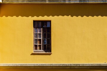Rustic yellow wall and wooden window. Copy space