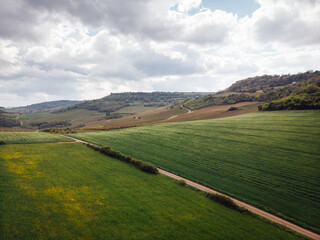 Naklejka premium Vue aérienne d'une route de campagne. Un paysage de campagne. Des collines, des champs, un plateau et une vallée.