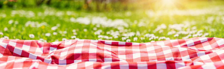 Closeup view of the picnic duvet on the meadow with green grass and spring flowers. - 506723005