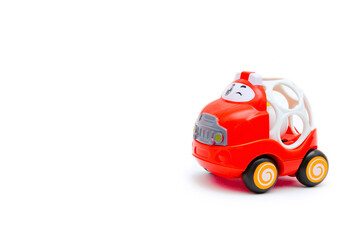 Colorful cute little mini red plastic car toy with teether for newborn babies isolated on white background mockup with copy space, toys for children,for boys, kids development, playing, childhood fun