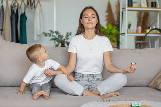 mom and son at home in the living room. parenting and business for a young European mom. A woman meditates and does yoga and plays with her son. sports and spiritual development. single mother