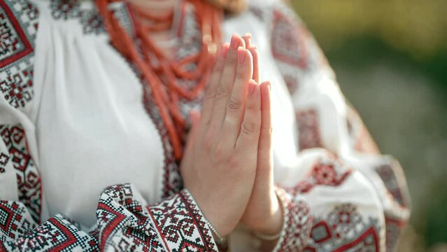 Pray for Ukraine, stand with. Ukrainian woman in traditional embroidery vyshyvanka dress holding hands in prayer gesture - anjali mudra.