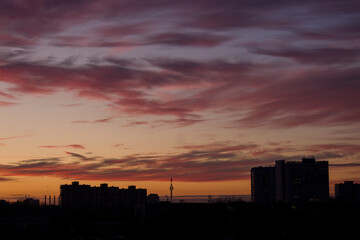 Beautiful violet sunset and purple clouds over the night city.