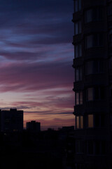 Beautiful violet sunset and purple clouds over the night city.