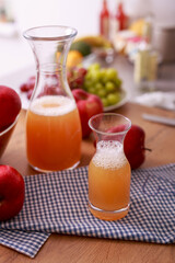 Fresh detox juice from fruit in glass bottles on kitchen counter