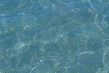 Blue pool water with sun glare abstract blurred background