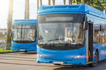Two blue city passenger buses at the bus terminus waiting for passengers to depart for the route...