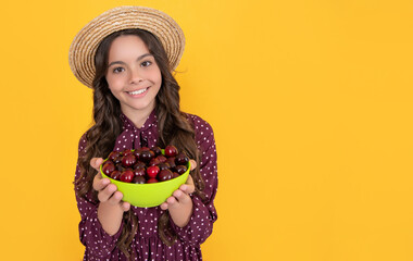 happy teen child hold cherry bowl on yellow background
