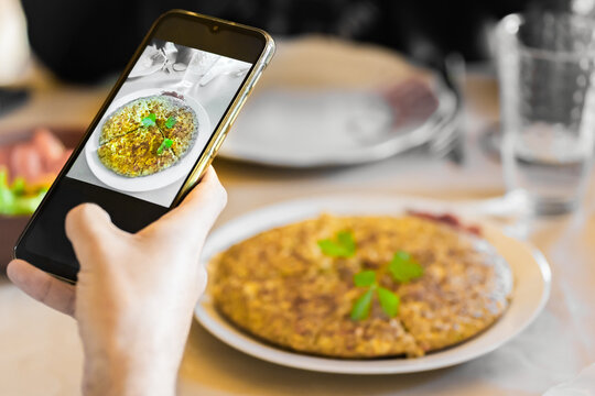 A hand taking a picture to a quinoa pie healthy food with a smartphone at restaurant