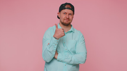 Obraz premium Lovely cheerful man in blue shirt greatly approves your suggestion, shaking head approvely, satisfied with good quality work, like proposal. Young adult guy boy isolated on pink studio wall background
