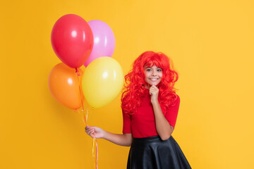 child smile with helium balloon on yellow background