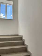 Concrete steps against white walls in a new house , construction concept
