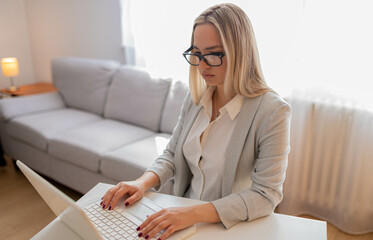 Young woman working at her home. Woman working at lap top. Happy business woman working at the desk.