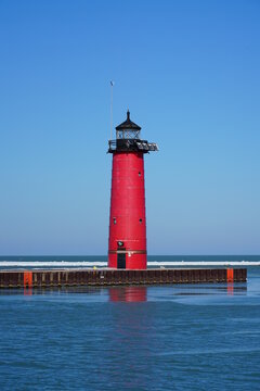 Red lighthouse standing in the bay of Lake Michigan 