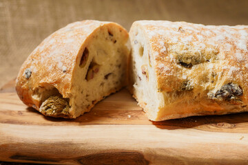 Fresh Mediterranean style bread with olives. Premium quality bakery product. Brown color background.