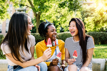 Cheerful multiethnic group of female friends talking and having fun together - Diverse tourist...