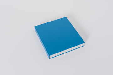 Mockup of a square book with a blank blue glossy cover on white background. Isolated with clipping path.