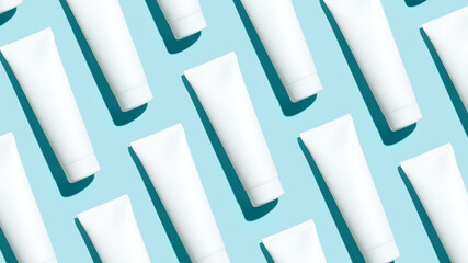 Pattern from mock up cosmetic tubes on blue background