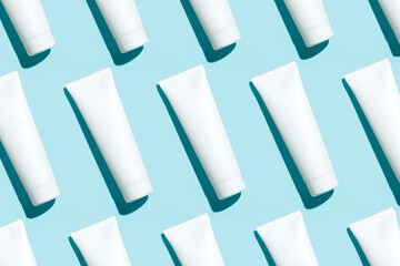 Pattern from mock up cosmetic or toothpaste tubes on blue background