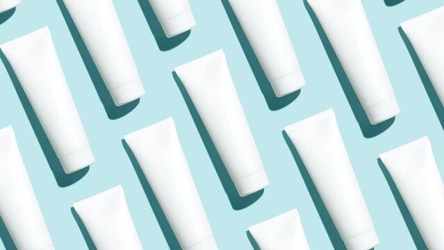 Pattern from mock up cosmetic or toothpaste tubes on blue background - Stop motion animation