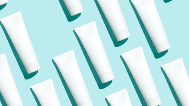 Pattern from mock up cosmetic or toothpaste tubes on blue background - Stop motion animation