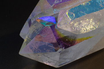 Colourful Angel Aura Quartz crystal point cluster on black surface