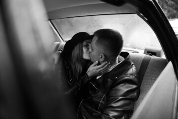 stylish couple kissing in the car 