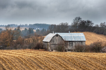 old barn in plowed field