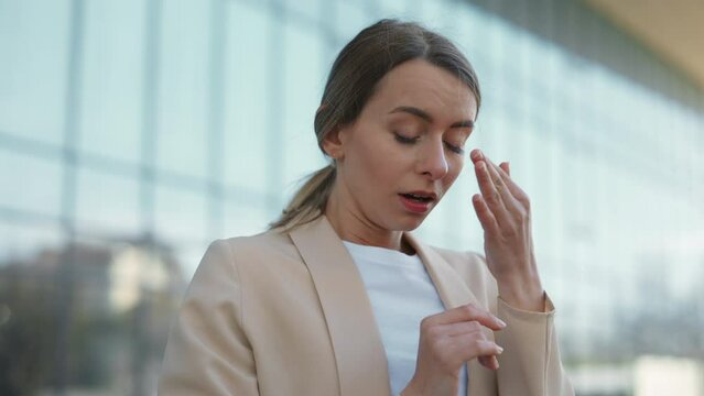 Stressed business woman crying while standing outside office building. Upset caucasian female in smart casual wear being fired from large international company.