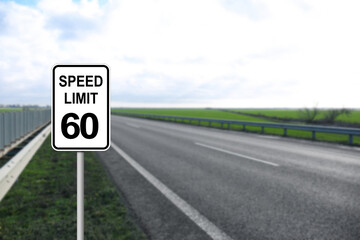 Traffic sign SPEED LIMIT 60 near empty asphalt road