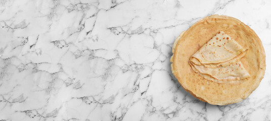 Delicious crepes on white marble table, top view with space for text. Banner design