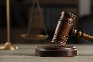 Wooden gavel on table against dark background. Space for text