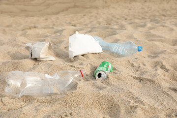 Different garbage scattered on sand. Recycling problem