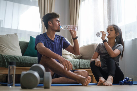 Healthy Couple Drinking Water, Take A Break After Workout At Home. Healthy Lifestyle, Yoga, Pilates, Exercising Concept.