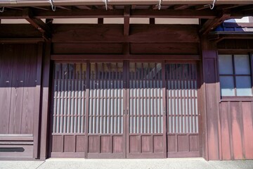 ベンガラ色の格子戸が粋な古い日本家屋の情景