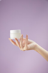  Front view of hand model using cosmetic jar in purple background for cosmetic advertising