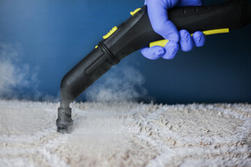 Cleaning and disinfection of a light-colored carpet with hot steam on an isolated background. Professional cleaning