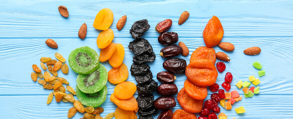 Different dried fruits and nuts on blue wooden background
