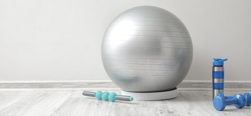 Set of sports equipment near light wall