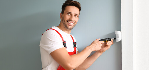 Technician installing smart home security system in room