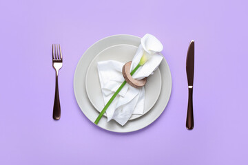 Beautiful table setting with calla lily on lilac background