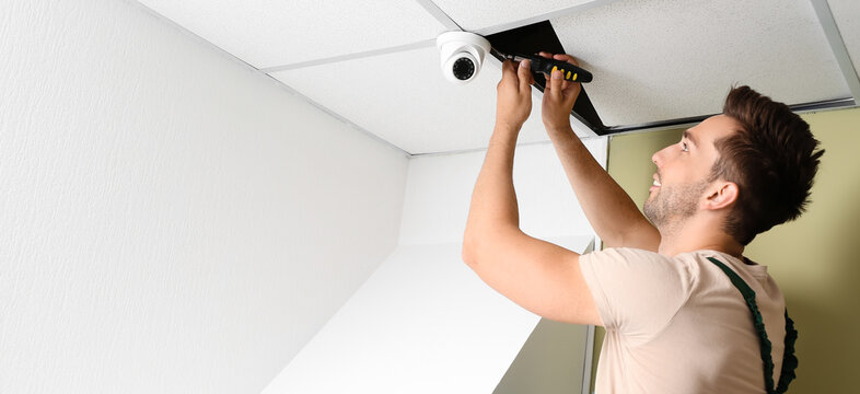 Technician installing smart home security system in room