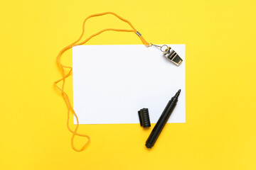 Blank paper sheet with marker and whistle on yellow background
